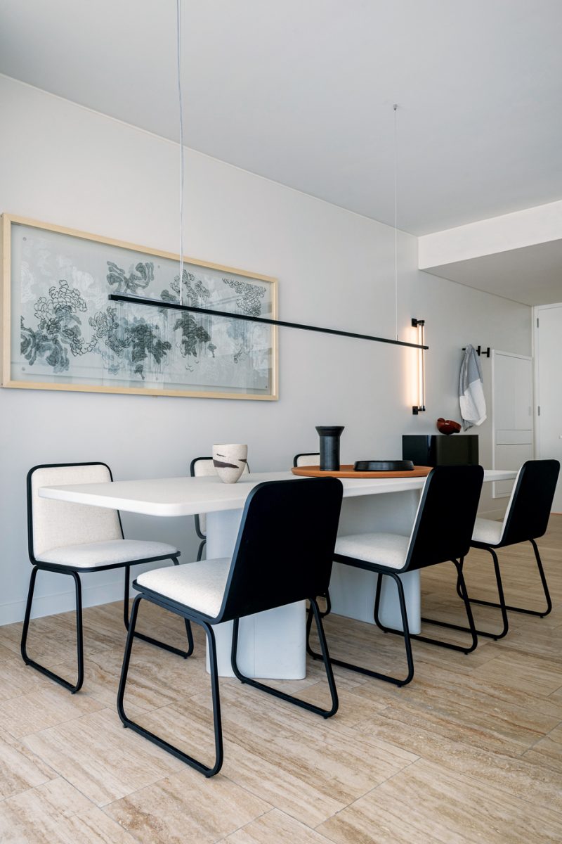 En el comedor, mesa y sillas de Ascolta. Cuadro de Michelle Dabul. La curaduría de objetos es de Casa Social. Lámpara sobre la mesa de Huup. Bandejas de cuero: Aldacour. Mueble del hall diseñado por el estudio, realizado por Moba. En las paredes, Sinteplast tono Luna Moon.