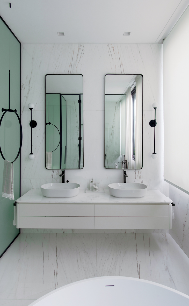 Baño de suite principal revestido en mármol. Mueble diseñado a medida. Apliques de pared de Jader Almeida.